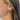 Side view of model wearing the Out Of Line Hoops which features open, small hoops covered with gold bars design.