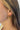 Side view of model wearing the Out Of Line Hoops which features open, small hoops covered with gold bars design.