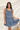 Frontal view of the Cross Roads Dress that features a blue and white floral pattern, a straight neckline, a sleeveless design with a thick ruffle strap, a tiered design, and a flowy fit.