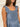 Frontal view of the Cross Roads Dress that features a blue and white floral pattern, a straight neckline, a sleeveless design with a thick ruffle strap, a tiered design, and a flowy fit.