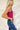 Side view of the West Side Bodysuit that features a magenta cotton material, a round neckline, a sleeveless design with thick straps, a bikini bottom, and a snap closure.