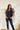 Frontal view of the Mirror Mirror Top that features a black sheer fabric, a rounded neckline with a sheer lining at the chest, a sheer puffy half sleeve, a flowy fit, and a button back.