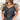 Frontal view of the Mirror Mirror Top that features a black sheer fabric, a rounded neckline with a sheer lining at the chest, a sheer puffy half sleeve, a flowy fit, and a button back.