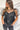 Frontal view of the Mirror Mirror Top that features a black sheer fabric, a rounded neckline with a sheer lining at the chest, a sheer puffy half sleeve, a flowy fit, and a button back.