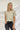 Frontal view of the On A Whim Tee that features a stone t-shirt material, a rounded neckline, a short sleeve, ruff details on the front sides, and a relaxed fit.