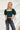 Frontal view of the Turn Back Time Top that features a green corduroy material, a straight neckline, a half puffy sleeve, a smocked back, and a cropped fit.