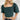 Frontal view of the Turn Back Time Top that features a green corduroy material, a straight neckline, a half puffy sleeve, a smocked back, and a cropped fit.