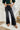 Frontal view of the Rooted Denim: Crue Flare Jeans that features a faded black wash denim, a front two button and zip closure, two front pockets, a frayed bottom hem, two back pockets, and a flare fit.