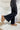 Side view of the Rooted Denim: Crue Flare Jeans that features a faded black wash denim, a front two button and zip closure, two front pockets, a frayed bottom hem, two back pockets, and a flare fit.