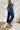 Side view of the Kancan: Maisie Straight Leg Jeans that features a dark wash denim with distress details, a high-rise fit, a front two button and zip closure, two front pockets, a faded ankle hem, two back pockets, and a straight leg fit.