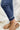 Detail view of the Kancan: Maisie Straight Leg Jeans that features a dark wash denim with distress details, a high-rise fit, a front two button and zip closure, two front pockets, a faded ankle hem, two back pockets, and a straight leg fit.