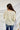 Back view of the Soul Searching Top that features an ivory material, a multi-colored floral print, a scoop neckline, a short flowy sleeve with a ruffle hem, and a flowy fit.