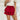 Frontal view of the Maeve Skort that features a red satin material, a thick elastic waist band with a tie detail, a ruffle tiered design, a shorts lining, and a mini length.