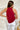 Back view of the Unwritten Tank Top that features a red material, a halter neck, a sleeveless design, a pointed front and back, and a flowy fit.