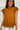 Frontal view of the Hampton Social Top that features a caramel material, a high rounded neckline with a ruffle hem, a short flowy sleeve, a pleated design, a lettuce edge bottom hem, and a flowy fit.