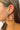 Side view of model wearing the Dream On Earrings in Multi which features medium, closed hoop covered with teal, fuchsia, light pink, orange and marigold beads.