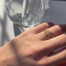 Front view of model wearing the Fantasy Dreams Ring which features dainty four gold bands, one band with three clear stones, one band with one clear stone and one band with multi clear stones.