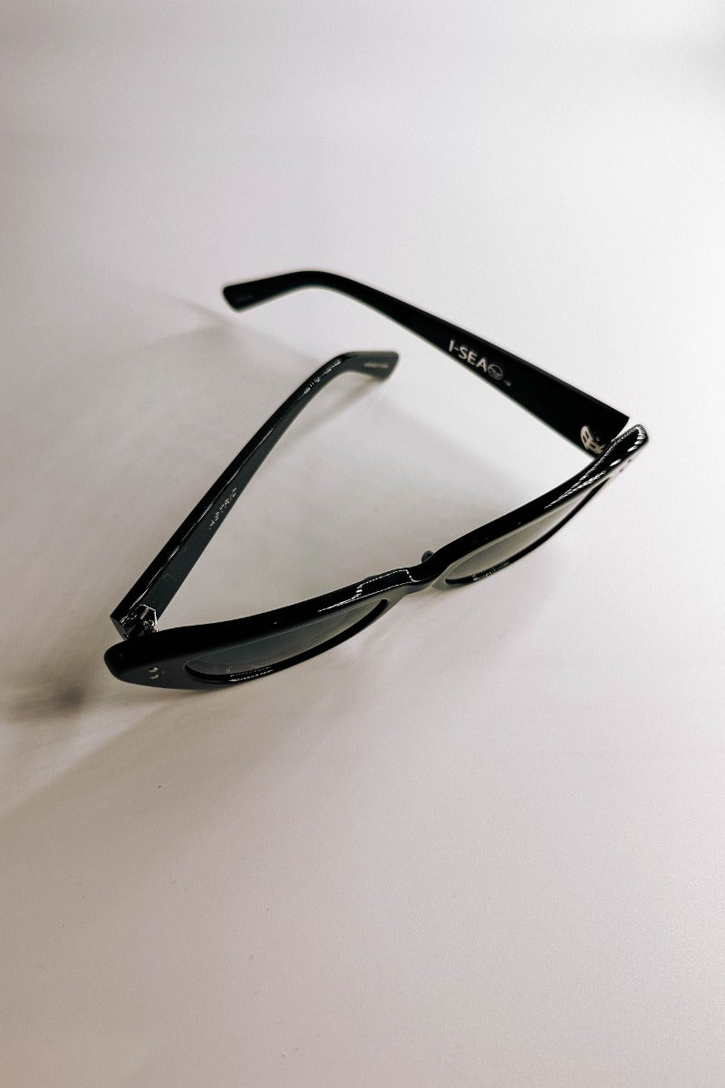 Ariel view of the I-Sea: Astrid Sunglasses in Black which features cat-eye shaped black frames with black lenses.