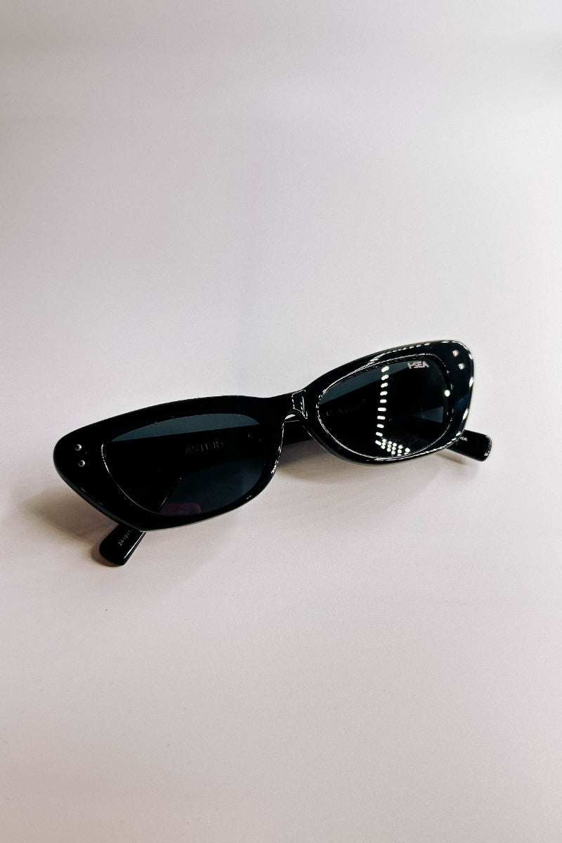 Front lay view of the I-Sea: Astrid Sunglasses in Black which features cat-eye shaped black frames with black lenses.