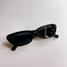 Front lay view of the I-Sea: Astrid Sunglasses in Black which features cat-eye shaped black frames with black lenses.