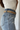 Side view of model wearing the Western Dreams Chain Belt which features thick gold chain with gold braided details and a gold buckle for closure.