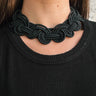 Front view of model wearing the Sadie Black Knot Necklace which features three black fabric layers intertwined together with a gold adjustable clasp closure.