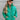 Close up view of model wearing the Call It Even Puffer Jacket features green puffer fabric, two front pockets, a high neckline, a silver zip up, and long sleeves