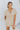 Frontal view of the Runaway Summer Romper that features a V neckline, a short cuffed sleeve, a ruched front, a cinched waist band, and a cuffed bottom hem.