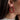 Close up view o fmodel wearing the Patricia Pearl Red Hoop which features medium red open hoops with mini pearl details.