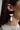 Side view of model wearing the Gemma Black Multi Shape Dangle Earring which features black half moon stud linked with a small gold half moon and a white teardrop.