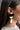 Side view of model wearing the Gemma Black Multi Shape Dangle Earring which features black half moon stud linked with a small gold half moon and a white teardrop.