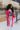 Full body front view of model wearing the You Are Fabulous Cardigan which features hot pink knit fabric with a long-line hem, front pockets, and long balloon sleeves with ribbed cuffs.