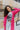 Front close up view of model wearing the You Are Fabulous Cardigan which features hot pink knit fabric with a long-line hem, front pockets, and long balloon sleeves with ribbed cuffs.
