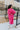 Back view full body of model wearing the You Are Fabulous Cardigan features hot pink knit fabric with a long-line hem, front pockets, and long balloon sleeves with ribbed cuffs.