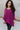 Front view of model wearing the This Is My Jam Sweater which features loose-knit magenta fabric with cuffed 3/4-length sleeves, a high-low hemline with side slits, and a rounded neckline.