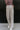 Front view of model wearing the You Should Be Dancing Pant which features taupe crinkle fabric, a zipper and hook closure, two front pockets and wide straight legs.