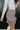 Side view of model wearing the Sitting Pretty Skirt which features a cream and brown geometric pattern fabric with frayed trim, a zipper on the side, and a lining.