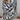 Close up view of model wearing the Positive Vibes Top which features satin fabric with a cream and black geometric print, a button-up front with a collared neckline, and long sleeves with buttoned cuffs.