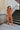 Full body view of the Talk To Me Jumpsuit which features rust corduroy fabric, a front zipper with a silver button closure, 2 chest pockets, 2 side pockets, a collared neckline and short sleeves.