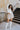 Full body front view of model wearing the Liana Mock Neck Top in Ivory, that features ivory ribbed fabric, high neckline, cropped waist and ribbed long sleeves.