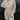 Close front view of model wearing the Pop The Champagne Dress, that has pleated champagne-colored fabric with metallic gold stripes, long sleeves with buttoned cuffs, a button-up front with a collared neckline, and a matching detachable belt