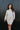 Front view of model wearing the Go Your Own Way Sweater Dress, that features beige knit fabric, a mock neckline, raglan balloon sleeves with ribbed cuffs, and a fitted ribbed hemline