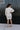 Full body back view of model wearing the Go Your Own Way Sweater Dress, that features beige knit fabric, a mock neckline, raglan balloon sleeves with ribbed cuffs, and a fitted ribbed hemline