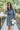Front view of model wearing the Great Escape Denim Dress, that has washed black lightweight denim, a button-up front with silver buttons, a collared neckline, long sleeves with ruffled elastic wrists, and side pockets