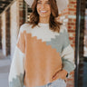 Front view of model wearing the Going West Sweater, that features ivory, peach, and light blue color blocking, a high round neckline, and long balloon sleeves with ribbed cuffs