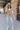 Full body front view of model wearing the Going West Sweater, that features ivory, peach, and light blue color blocking, a high round neckline, and long balloon sleeves with ribbed cuffs