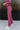 Side view of model wearing the Checked Out Pants, that have a monochromatic textured checker pattern, a high-rise elastic waist, flared legs, and a thigh-length lining