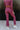 Back view of model wearing the Checked Out Pants, that have a monochromatic textured checker pattern, a high-rise elastic waist, flared legs, and a thigh-length lining