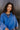 Close front view of model wearing the Long Live Sweatshirt, which features washed blue fabric, a 3/4 snap-up neckline with a small collar, raglan balloon sleeves with ribbed cuffs, and a ribbed hemline