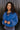 Front view of model wearing the Long Live Sweatshirt, which features washed blue fabric, a 3/4 snap-up neckline with a small collar, raglan balloon sleeves with ribbed cuffs, and a ribbed hemline